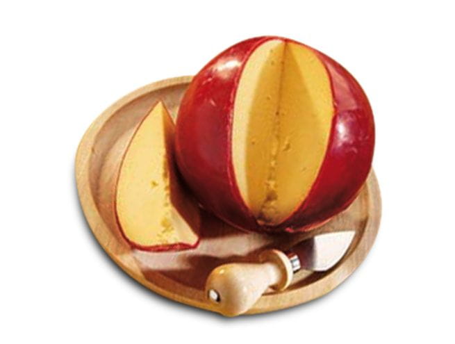 Round cheese with a wax coating, partially sliced, presented on a wooden board with a cheese knife