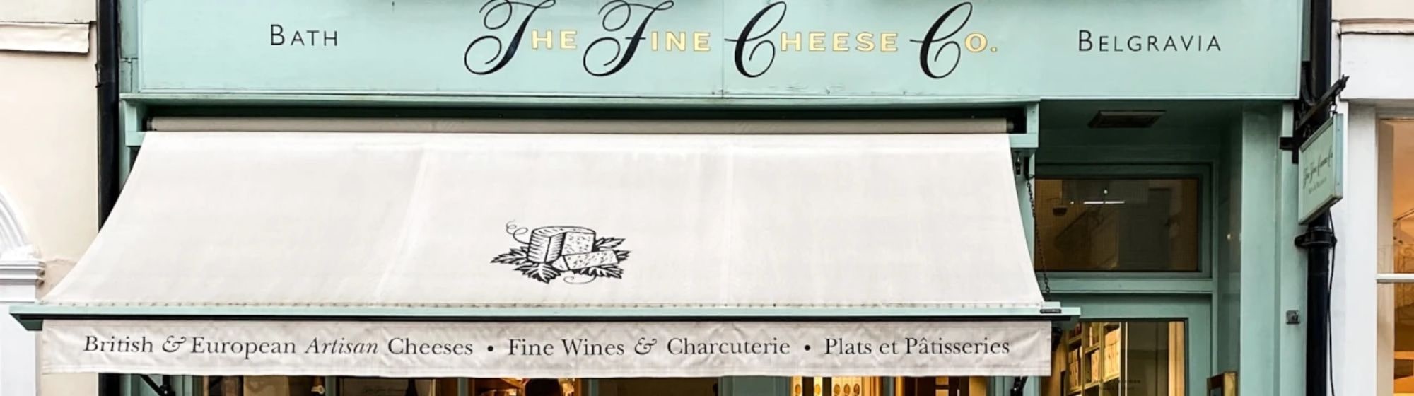 A picture of the storefront of the The fine cheese co shop. 