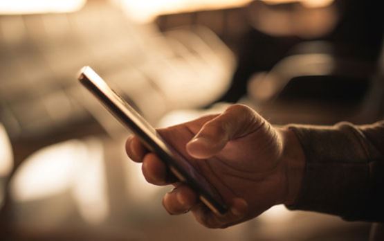 Image of a person holding a telephone in his hand