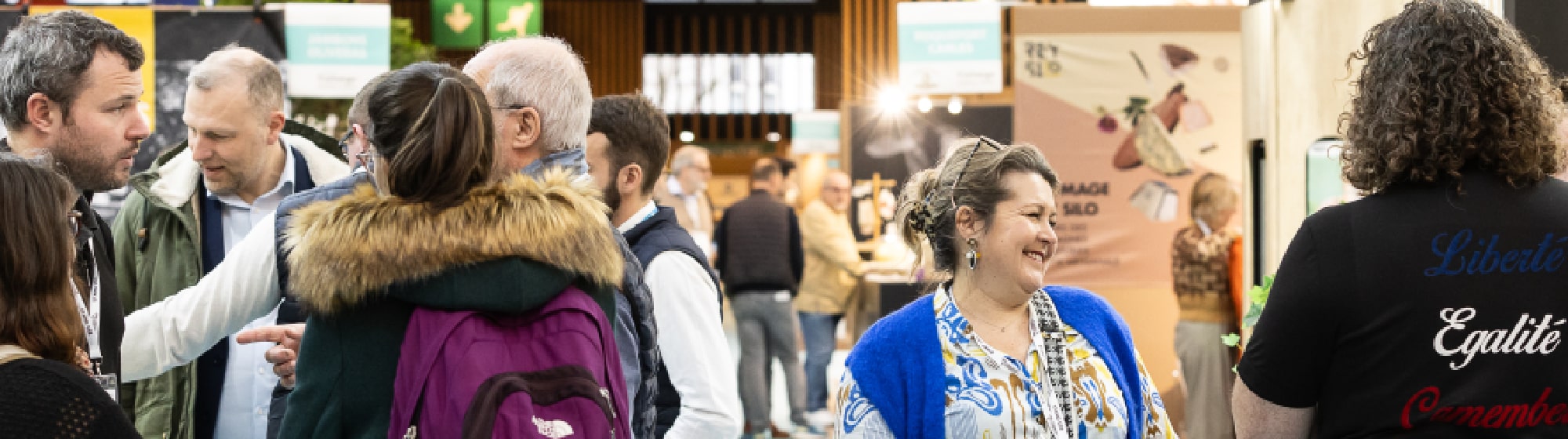 Des exposants discutant avec des visiteurs. 