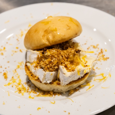 Un sandwich avec du fromage de chèvre et des miettes de biscuits.
